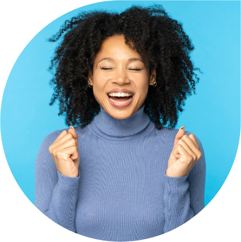 Smiling woman with curly hair celebrating joyfully.